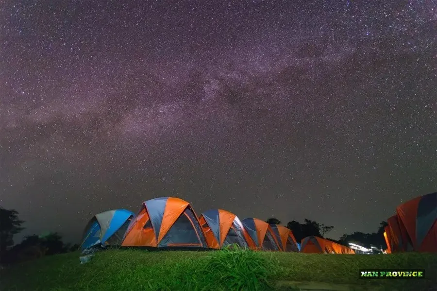 Tents pitched along the open ridge of Doi Samer Dao under a starlit mountain sky in Nan.
